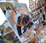 Een bewerkte foto van de Iraanse president Ahmadinejad in een SS-uniform als stille getuige van protesten tegen het Iraanse regime in Frankfurt. Afb: dpa/Picture Alliance