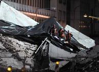 Bergingswerkers spannen plastic over de restanten van het Keulse stadsarchief. Zo hoopt men de stukken die onder het puin bedolven liggen tegen regenwater te beschermen. Afb: dpa/Picture Alliance